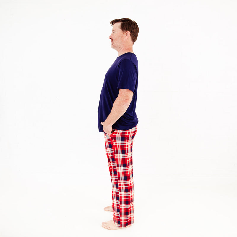 Man wearing a navy t-shirt and red plaid pajama.