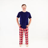 Man wearing a shirt and plaid pajama pants.