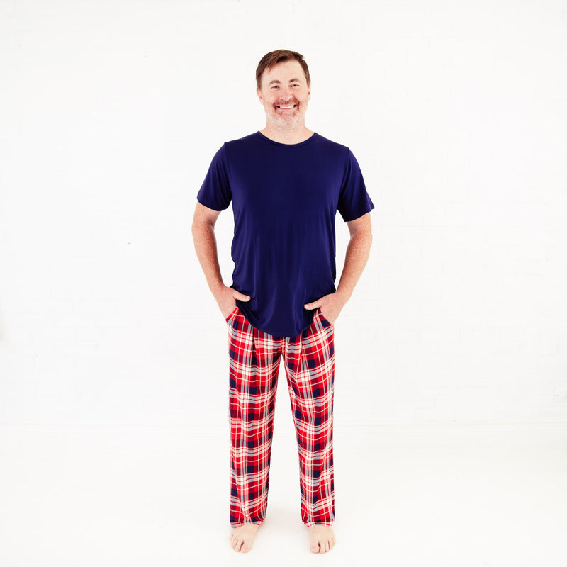 Man wearing a shirt and plaid pajama pants.