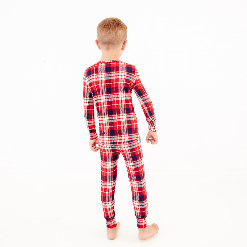 The back of a child in red plaid pajamas. 