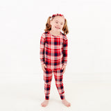 Little girl in red plaid pajamas.