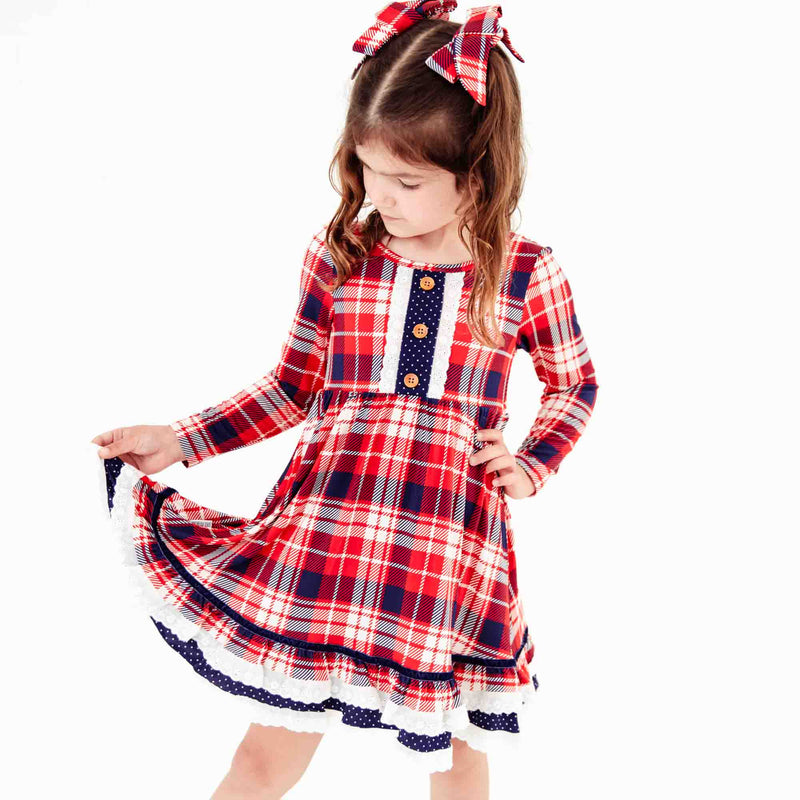 Girl wearing a red plaid holiday dress. 