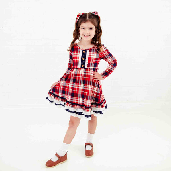Girl wearing a red plaid holiday dress. 