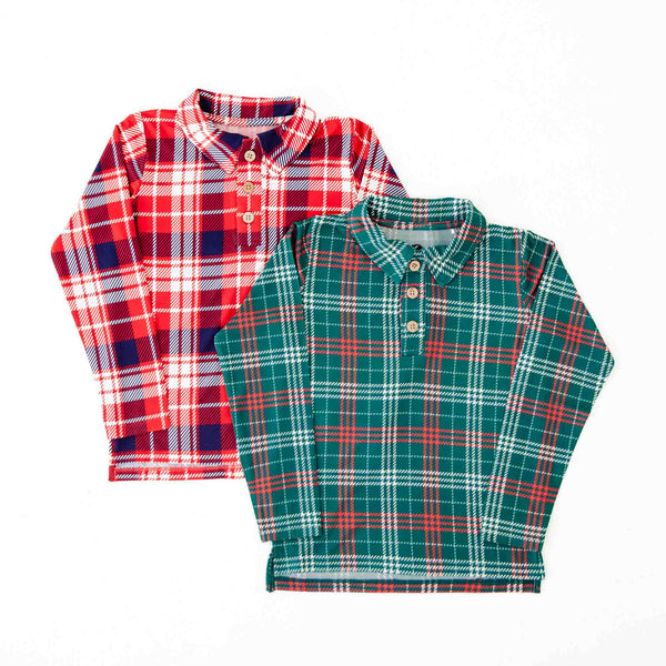 Two plaid polo shirts layered on the floor. 