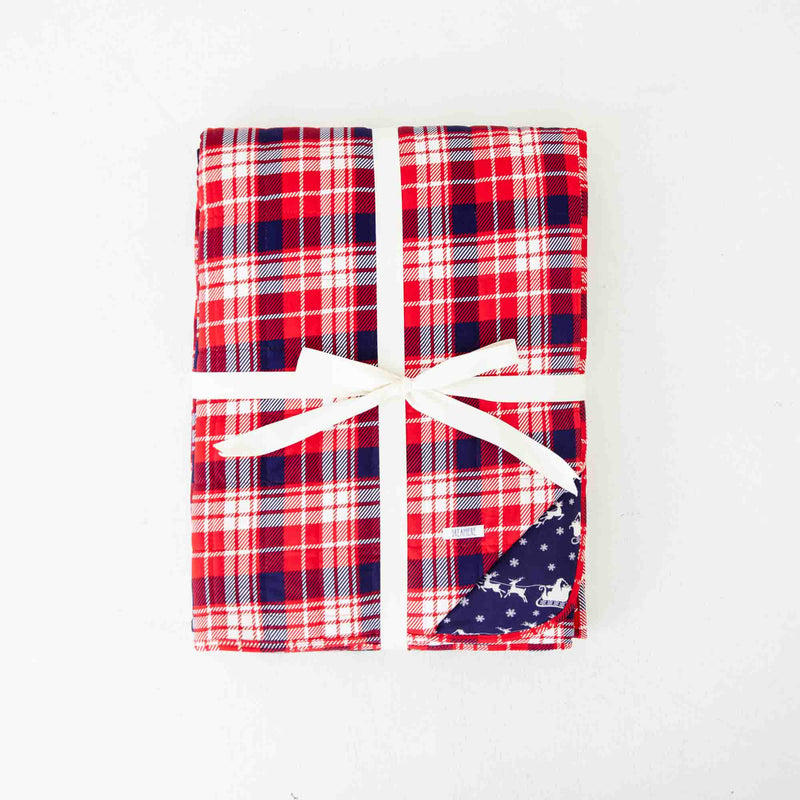 Folded red plaid bamboo blanket . 