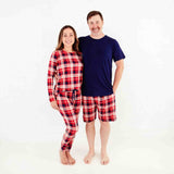 Couple wearing coordinating holiday pajamas. 