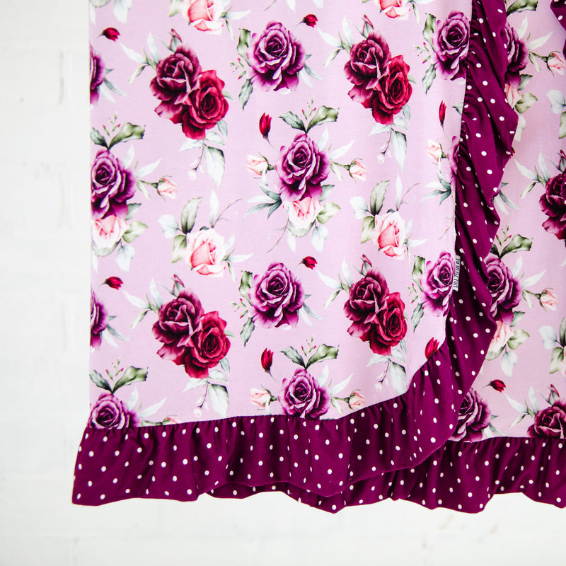 Floral blanket with polka dot ruffle trim. 