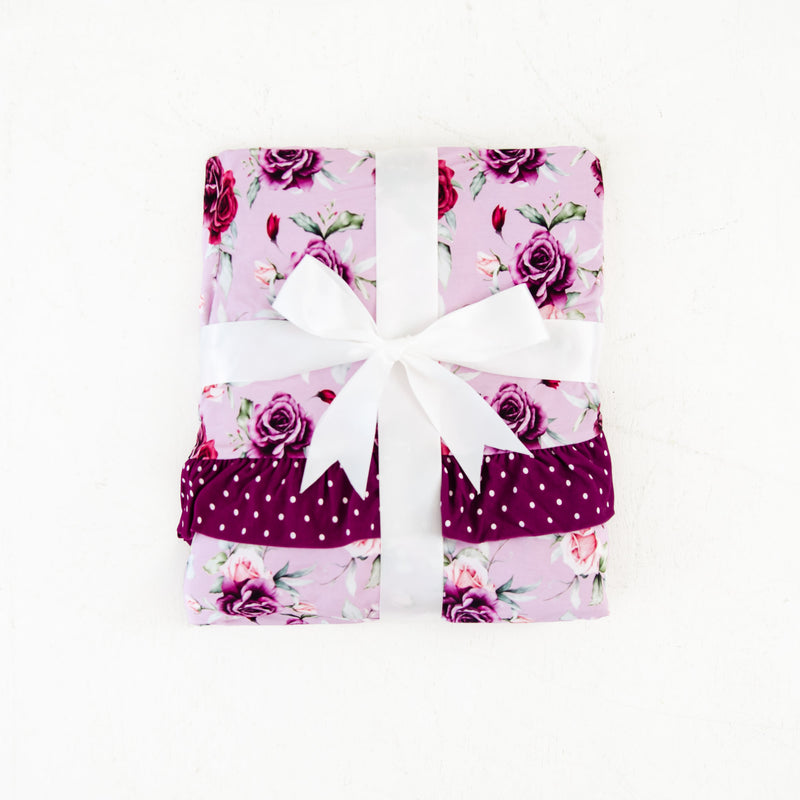Folded blanket with rose print. 
