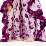 Girls standing with matching floral pajamas and blanket. 