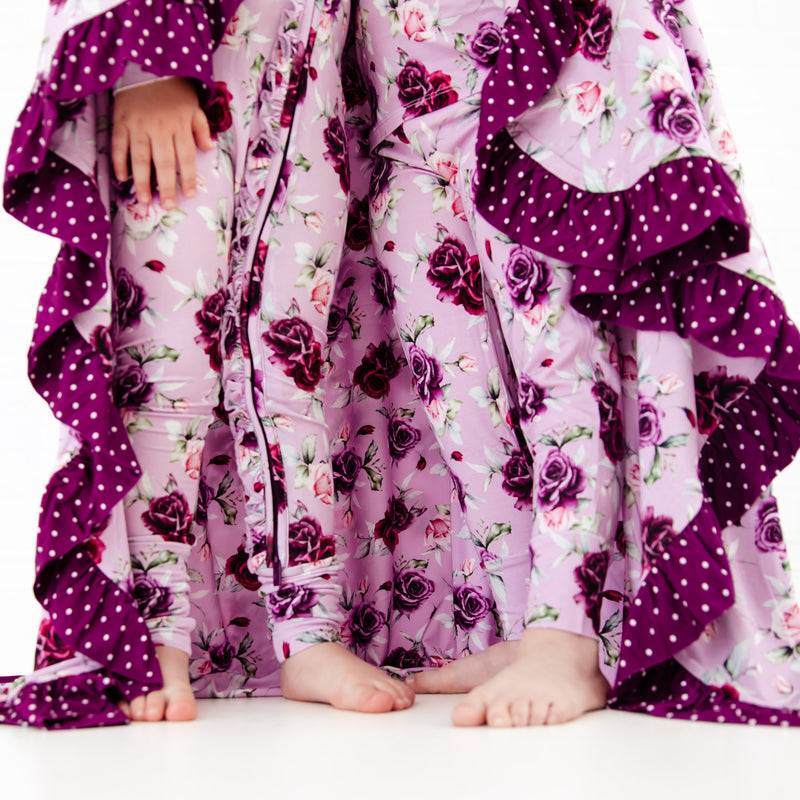 Girls standing with matching floral pajamas and blanket. 