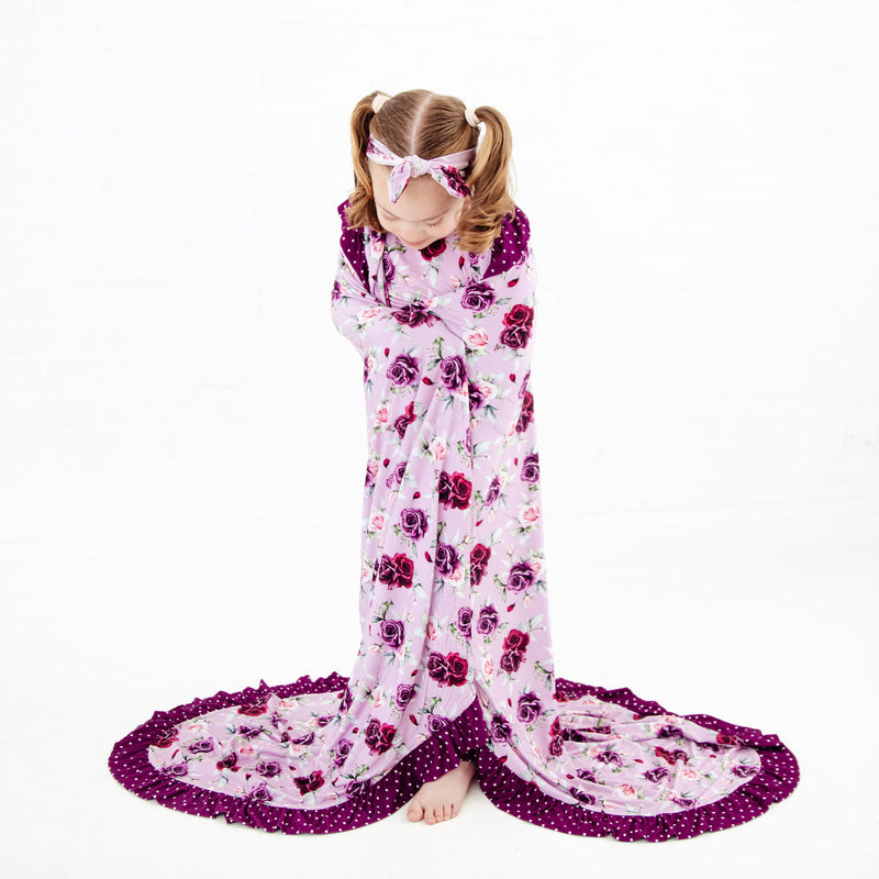 Child wrapped in a floral bamboo blanket.