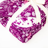 Purple floral blanket with santa's sleigh background.