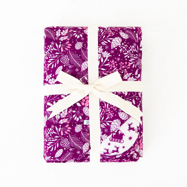 Folded purple floral holiday themed bamboo blanket.