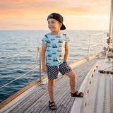 Child on a sailboat deck with a sunset in the background