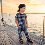 Child standing on a boat deck with a sunset in the background