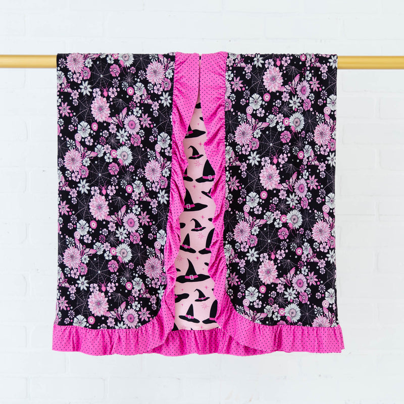 Ruffle reversible blanket with spooky floral print.