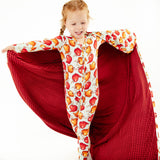 Child wearing pajamas with a matching blanket.