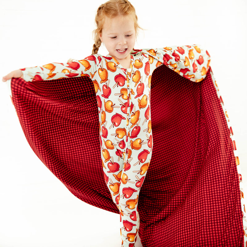 Child wearing pajamas with a matching blanket.