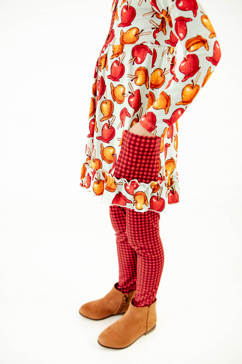 Girl wearing an outfit with a caramel apple print.