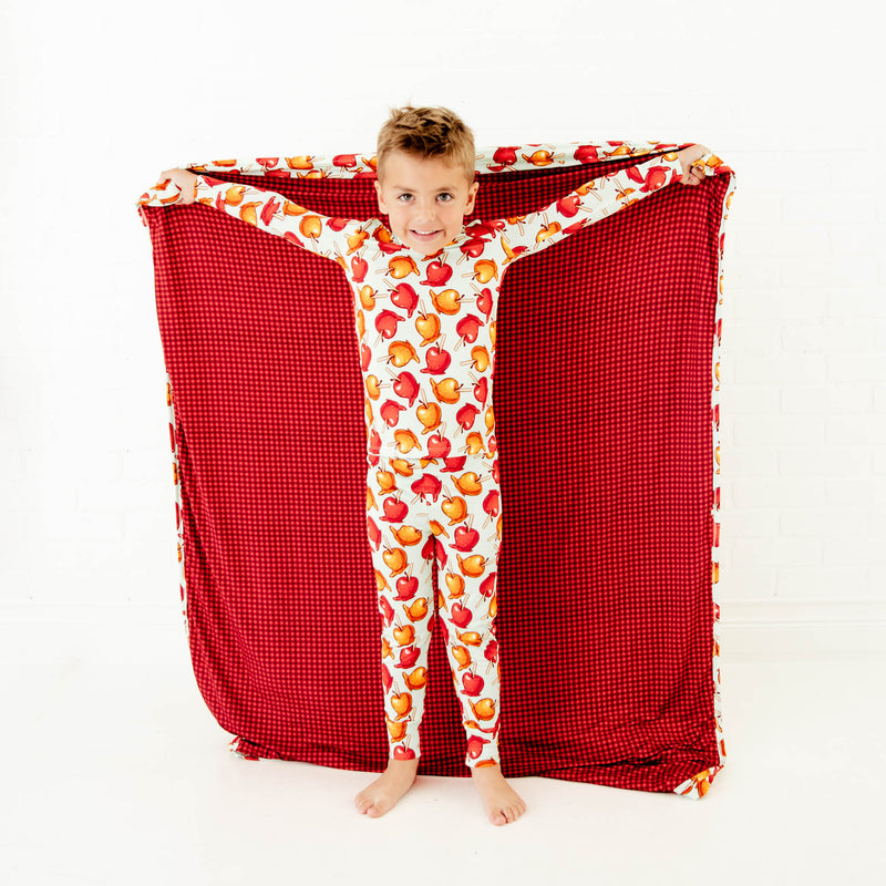 Child holding a blanket matching their fall pajamas. 