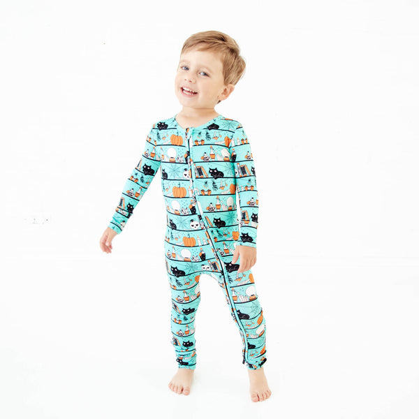 Boy wearing teal halloween themed pajamas. 
