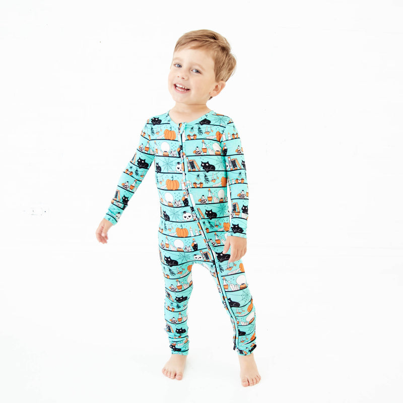 Boy wearing teal halloween themed pajamas. 