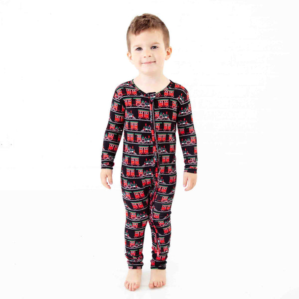 Boy in zipped pajamas with trains. 