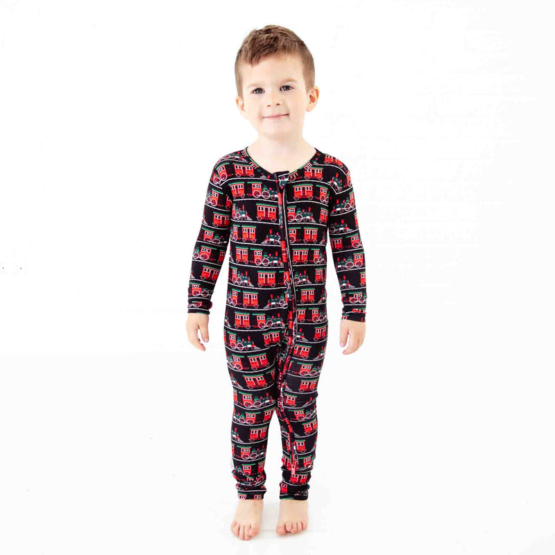Boy in zipped pajamas with trains. 