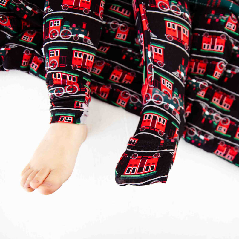 Children's feet in footed pajamas with trains. 