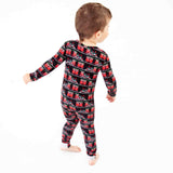 Boy dancing in holiday train pajamas. 