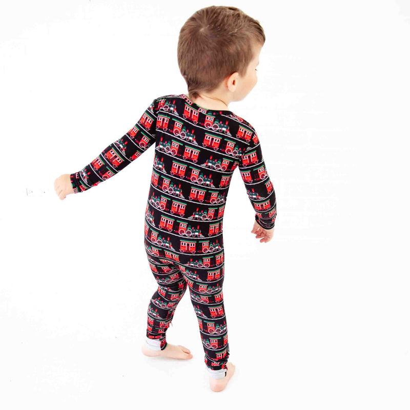 Boy dancing in holiday train pajamas. 