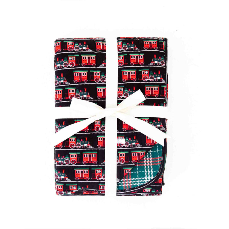 Folded Holiday Blanket with trains and plaid. 