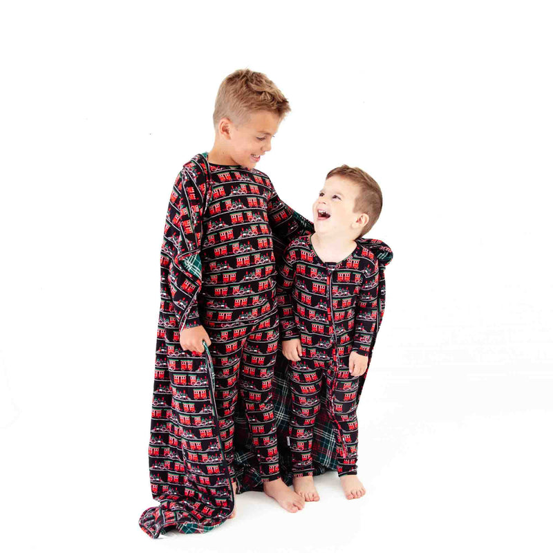 Two matching boys sharing a holiday blanket. 